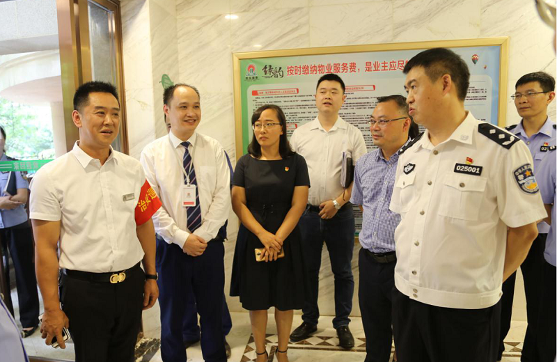 何绍明副市长（右一）向平安楼栋管家（左一）相识情形